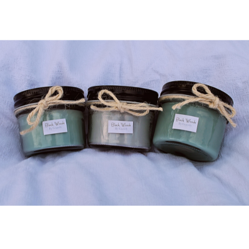 Three Black Woods Candles by Gravely Goods sitting on cloth
