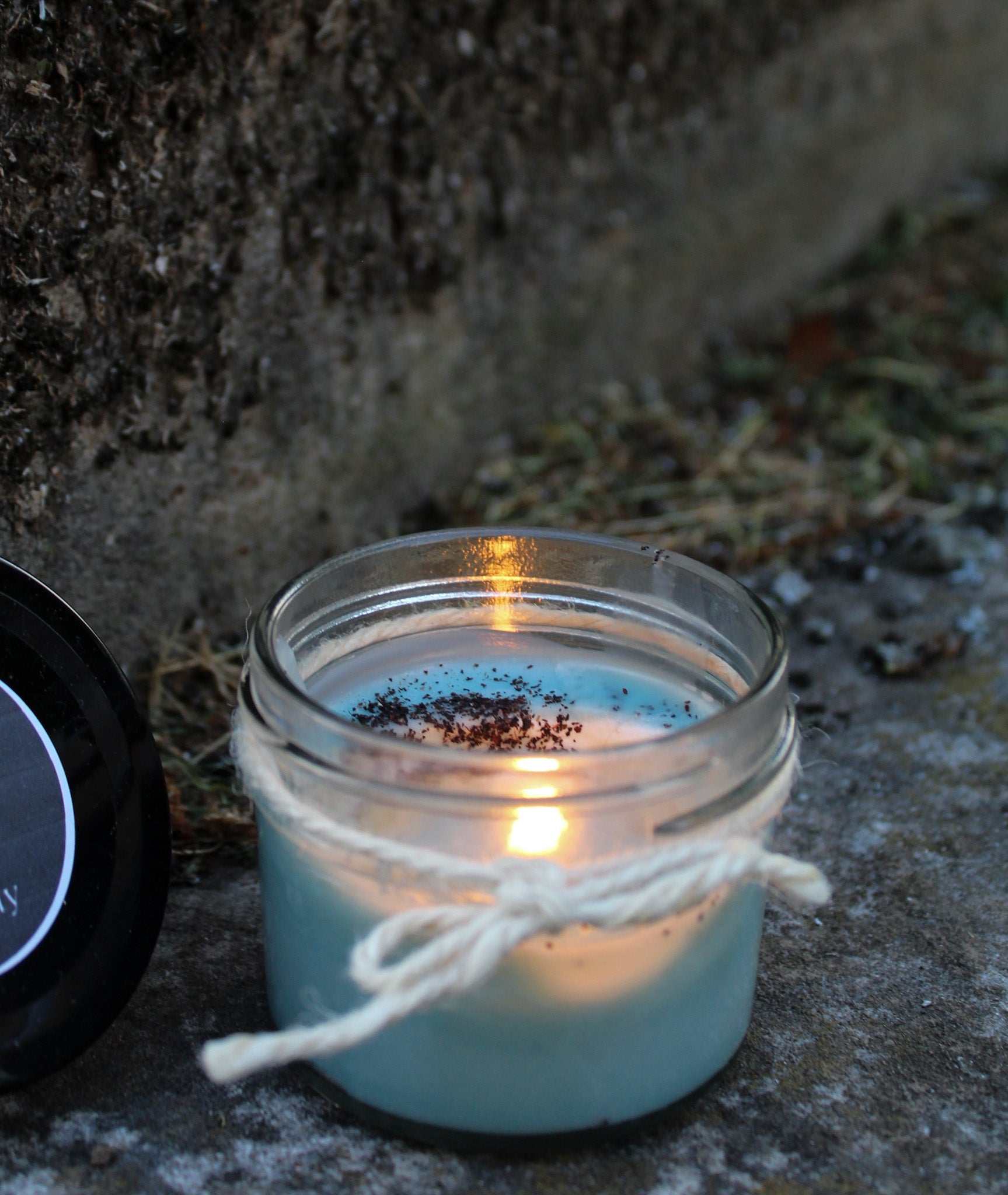 Lit Black Woods Candles by Gravely Goods and black lid